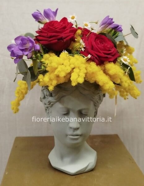 Composizione con mimosa ,rose rosse e fiori di stagione su vaso neo-classico